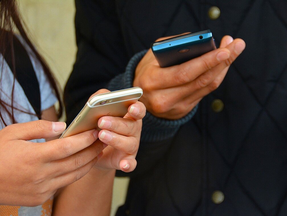 Jugendliche halten Smartphones in den Händen